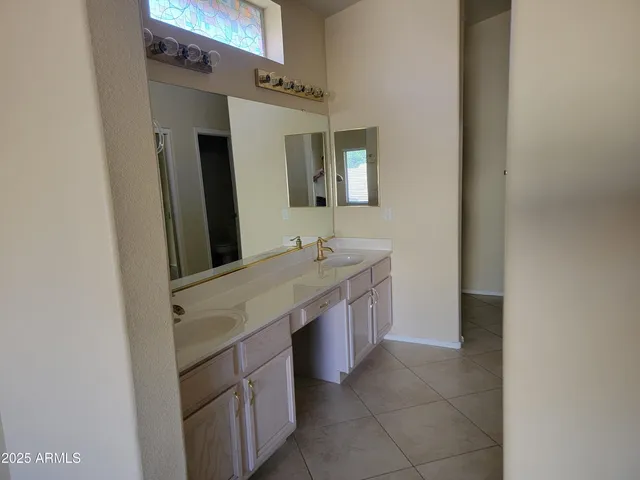 a bathroom with a granite countertop sink a mirror and a vanity