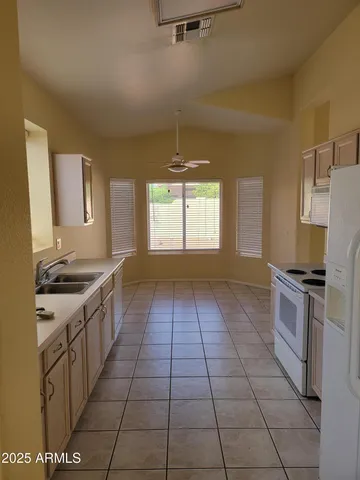 a kitchen with a sink a stove top oven and cabinets