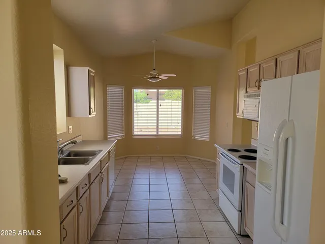 a kitchen with granite countertop a refrigerator and a sink