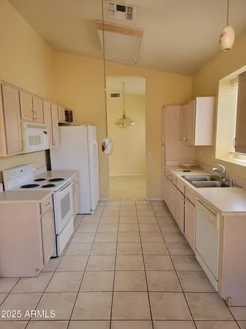 a kitchen with granite countertop a stove a sink and a refrigerator
