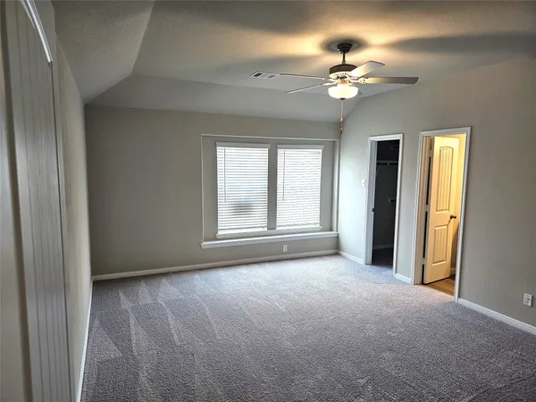 a view of an empty room with a chandelier fan