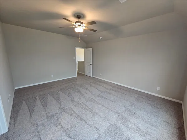 a view of an empty room with a chandelier fan