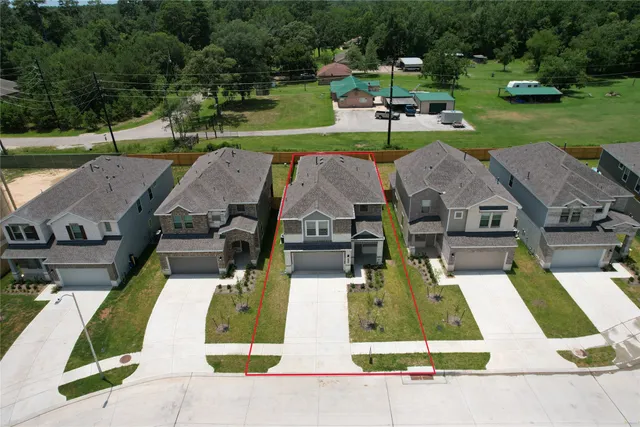 an aerial view of a house with a garden and lake view