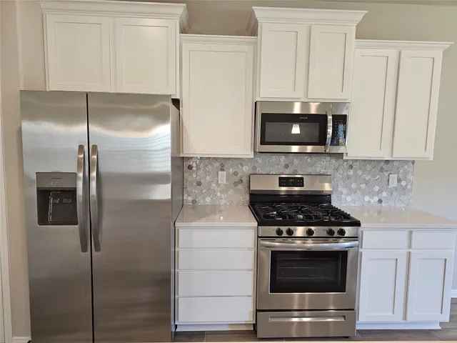 a kitchen with stainless steel appliances wooden cabinets and a stove top oven