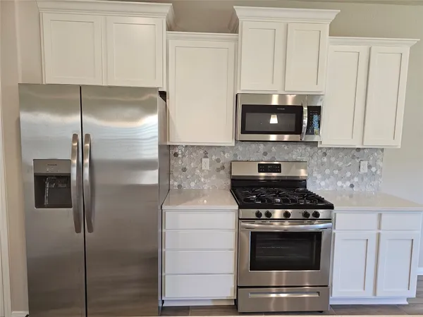 a kitchen with stainless steel appliances wooden cabinets and a stove top oven
