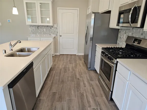 a kitchen with a sink stove and refrigerator
