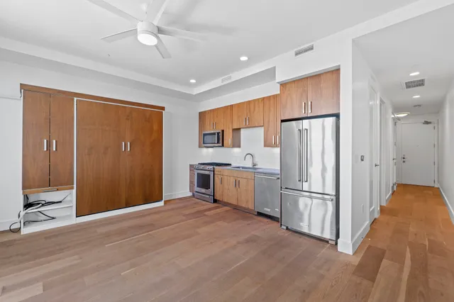 a kitchen with refrigerator cabinets and wooden floor