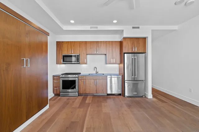 a kitchen with a refrigerator and a stove top oven