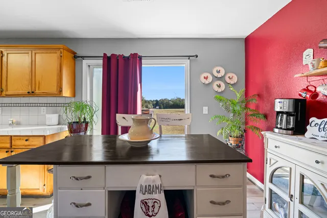 a kitchen with a table chairs and workspace