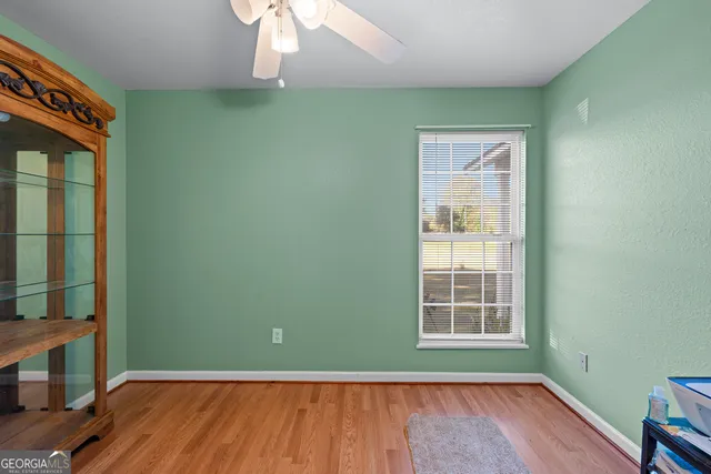 an empty room with wooden floor closet and windows