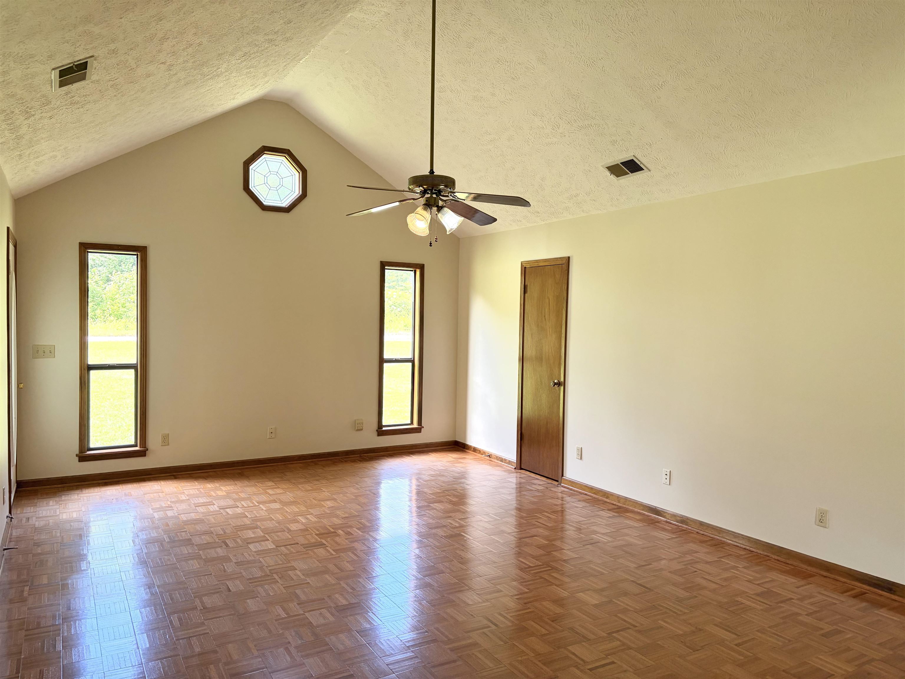640 Red Bird Road Middleton, TN 38052 - Photo 4 of 30 Spacious room featuring a vaulted ceiling and wood-finish parquet flooring