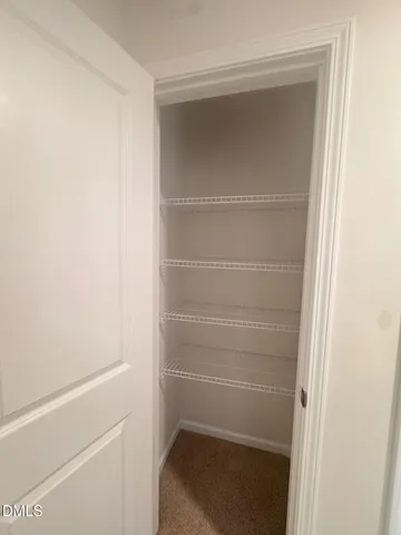 a view of a hallway with closet and wooden floor
