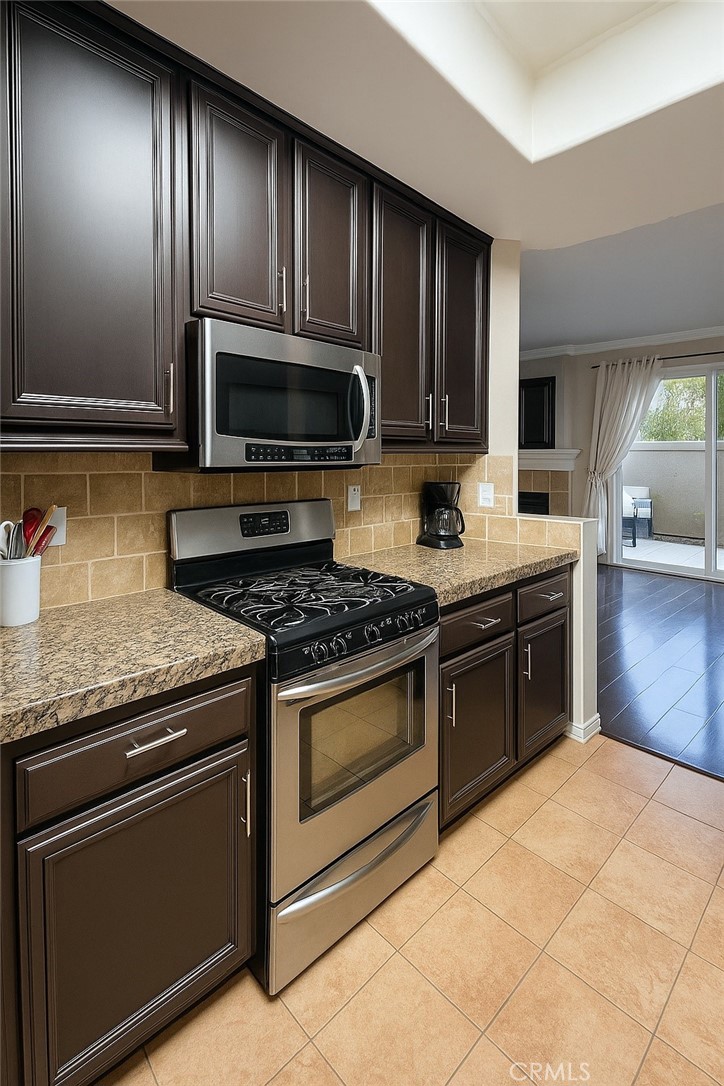 16706 Tim Lane Van Nuys, CA 91406 - Photo 6 of 16 a kitchen with granite countertop wooden cabinets stainless steel appliances and a counter space