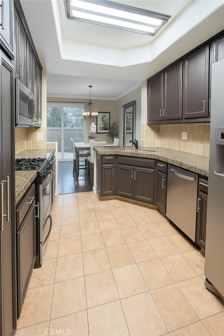 16706 Tim Lane Van Nuys, CA 91406 - Photo 7 of 16 a kitchen with stainless steel appliances granite countertop a stove top oven a sink dishwasher and cabinets