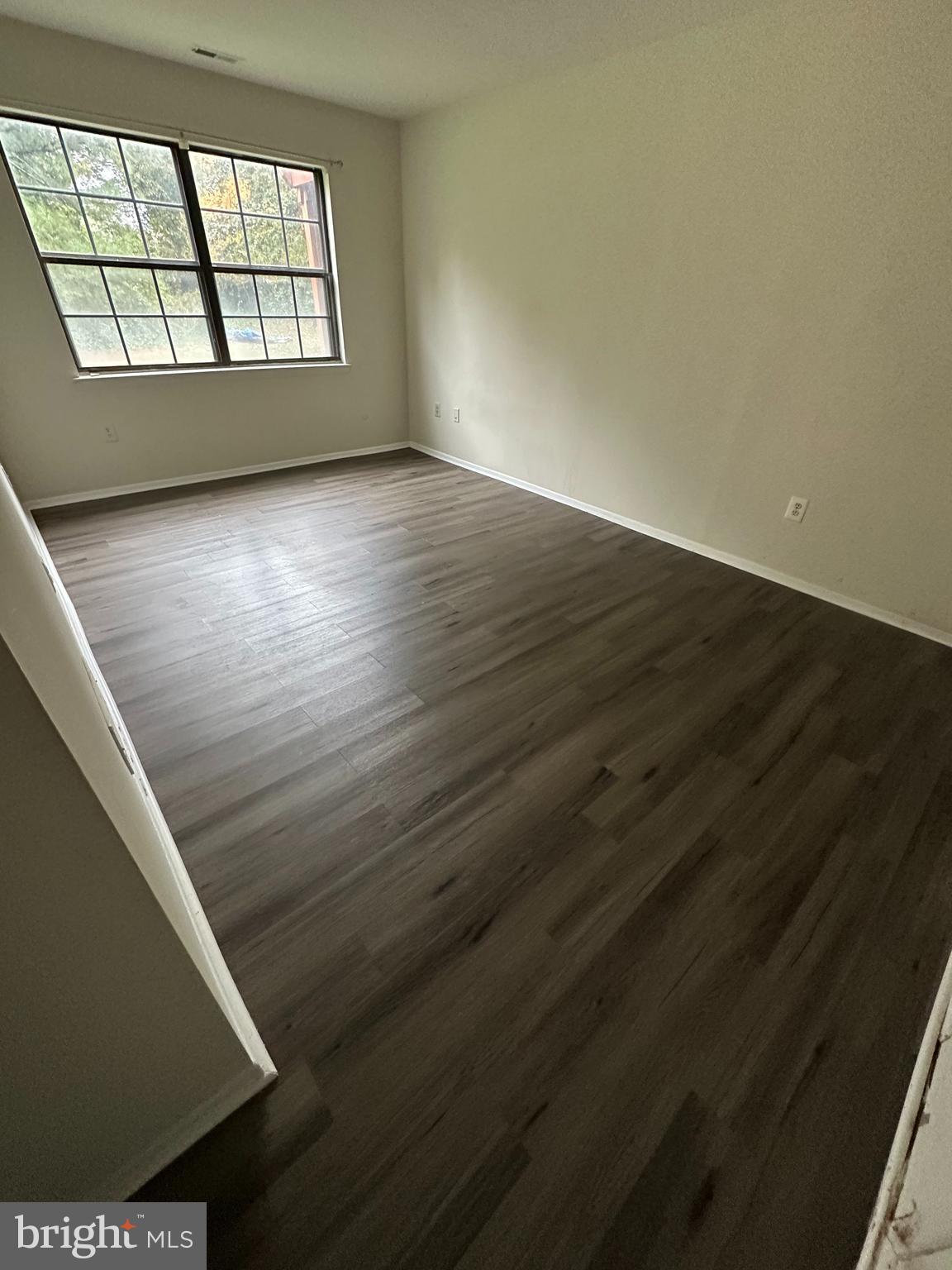 104 Willow Turn, Unit A Mount Laurel, NJ 08054 - Photo 7 of 8 a view of an empty room with wooden floor and a window