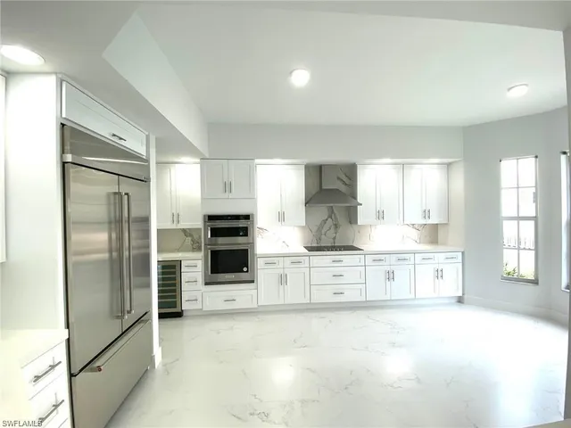 a large kitchen with kitchen island a sink stainless steel appliances and cabinets