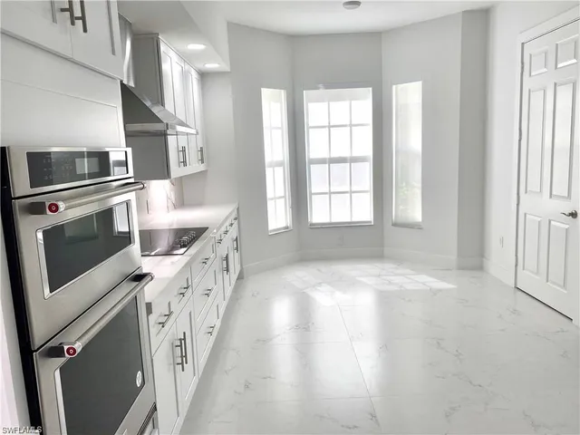 a kitchen with stainless steel appliances granite countertop a stove a sink and a refrigerator