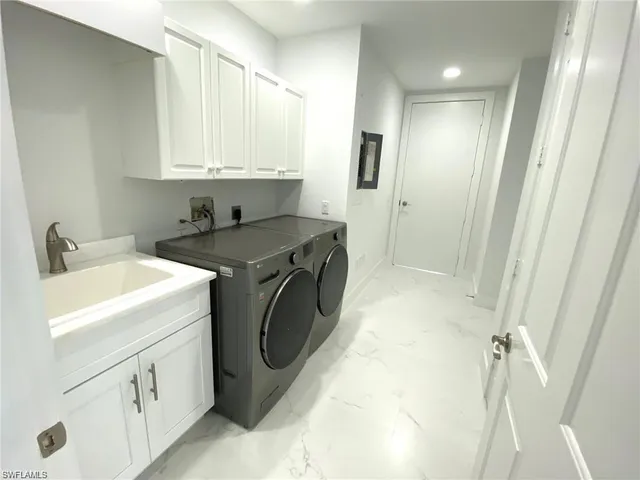 a utility room with cabinets washer and dryer