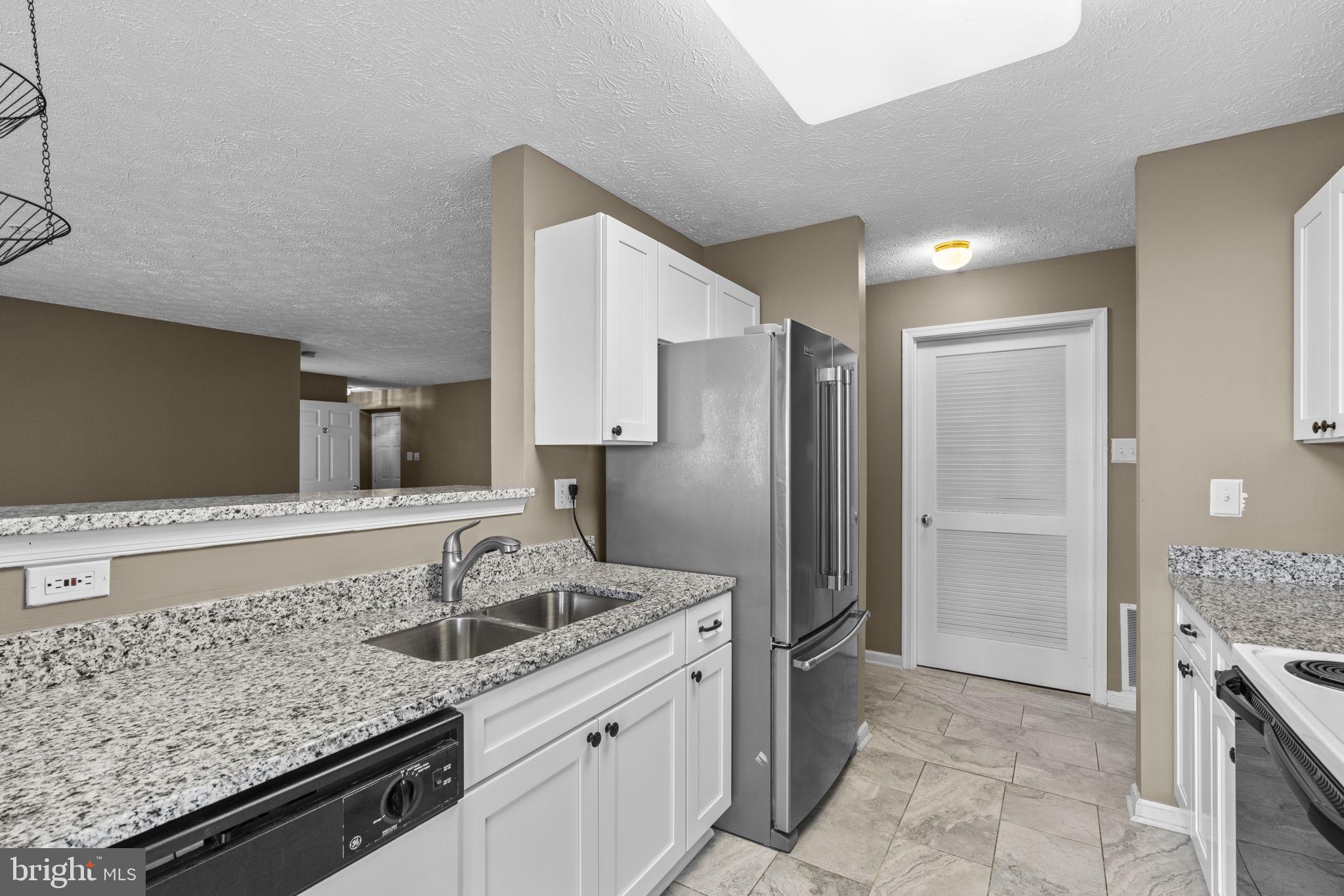 9713 Reese Farm Road, Unit 9713 Owings Mills, MD 21117 - Photo 12 of 30 a kitchen with a sink stove and refrigerator