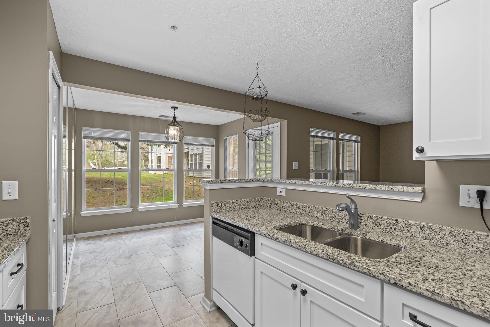 9713 Reese Farm Road, Unit 9713 Owings Mills, MD 21117 - Photo 13 of 30 a kitchen with granite countertop a sink and a counter top space