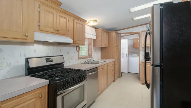 a kitchen with stainless steel appliances granite countertop a stove and a refrigerator