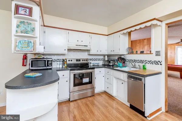 a kitchen with stainless steel appliances granite countertop a stove a sink and a refrigerator