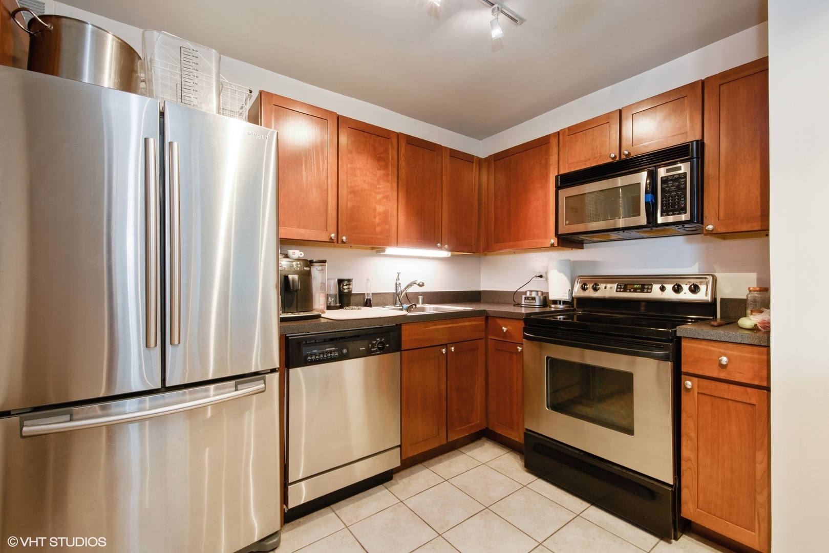 655 West Irving Park Road, Unit 1614 Chicago, IL 60613 - Photo 7 of 22 a kitchen with stainless steel appliances granite countertop a refrigerator stove top oven and sink