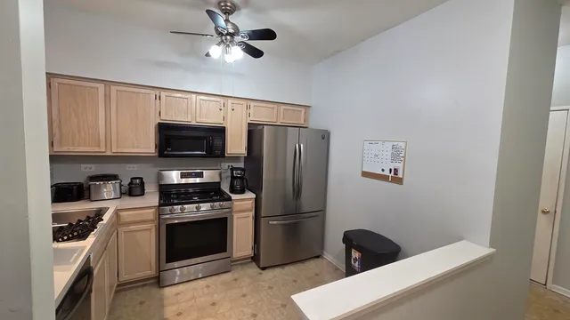a kitchen with stainless steel appliances kitchen island a stove and a refrigerator