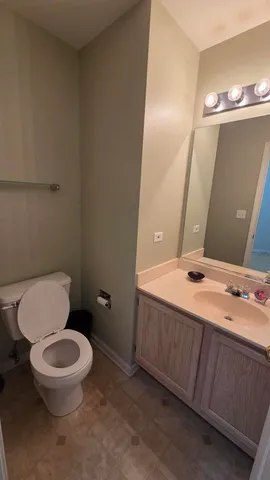 a bathroom with a toilet a sink and mirror