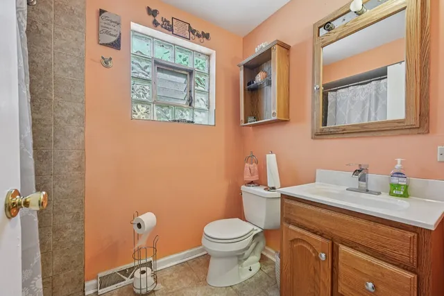 a bathroom with a toilet sink vanity and mirror