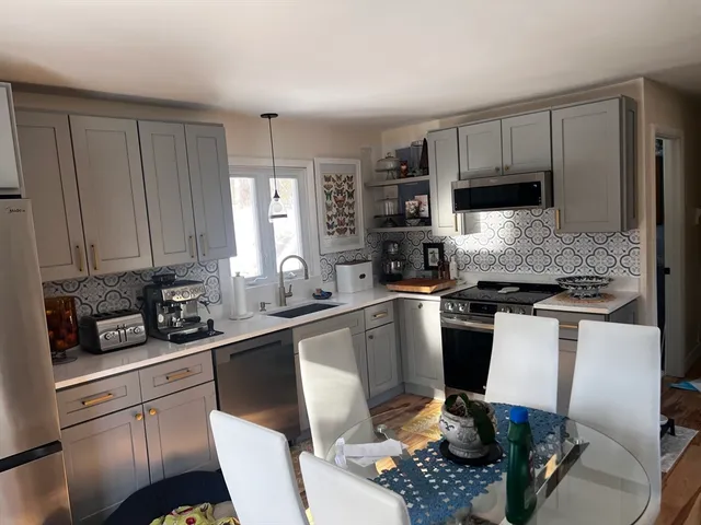 a kitchen with a sink stove and white cabinets