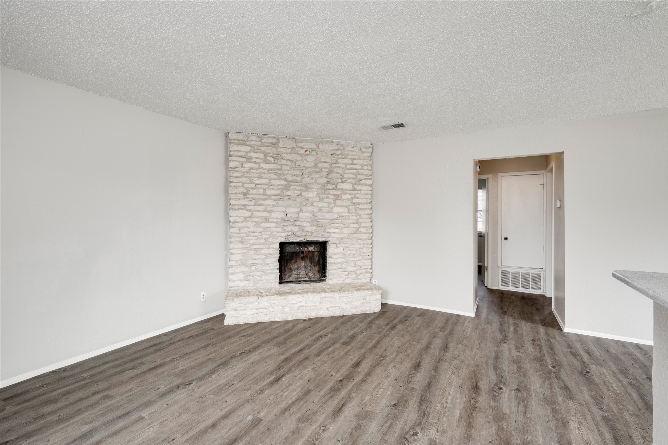 11907 Alpheus Avenue, Unit D Austin, TX 78759 - Photo 1 of 26 a view of an empty room with wooden floor fireplace and a window