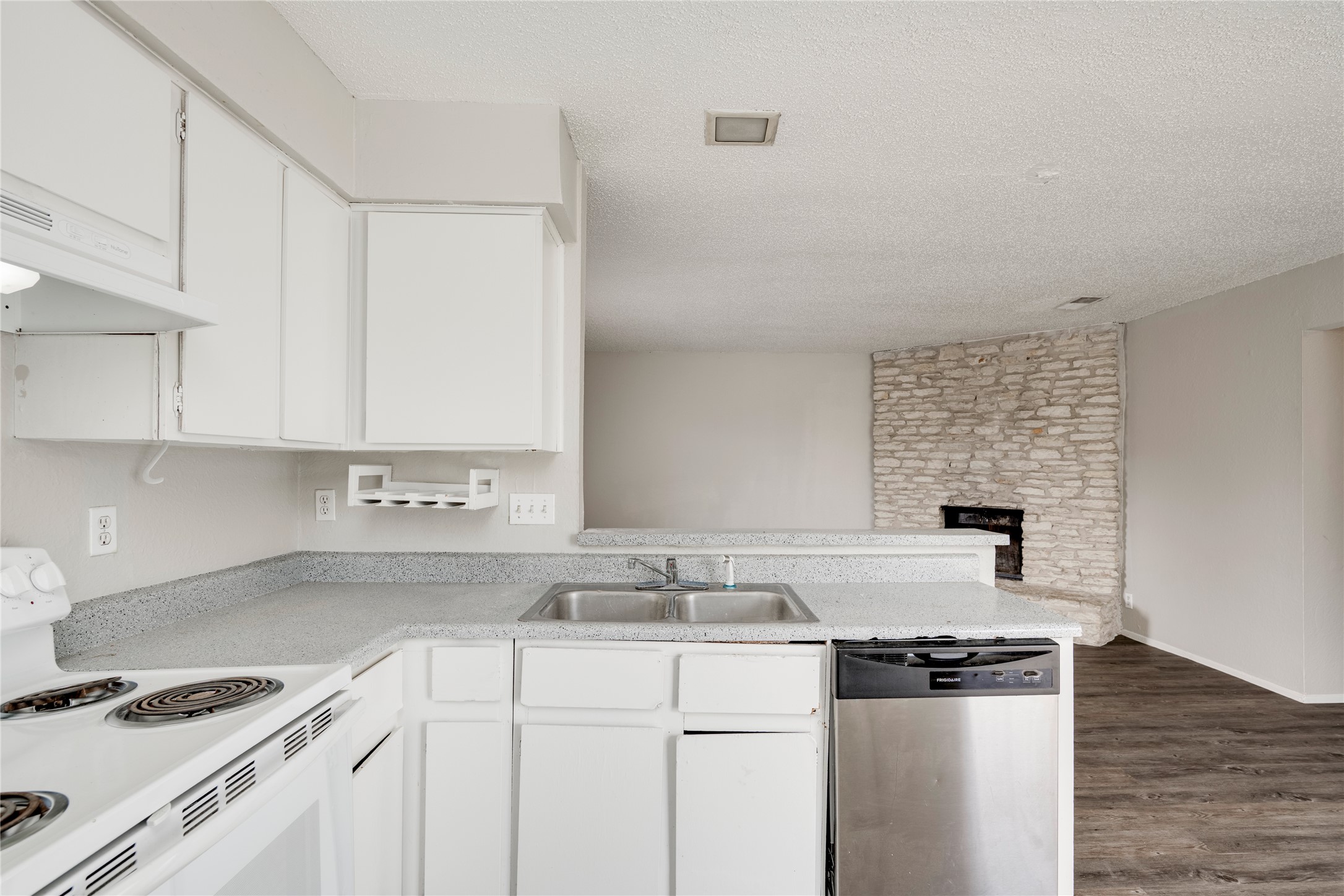 11907 Alpheus Avenue, Unit D Austin, TX 78759 - Photo 11 of 26 a kitchen with granite countertop a sink stove and white cabinets
