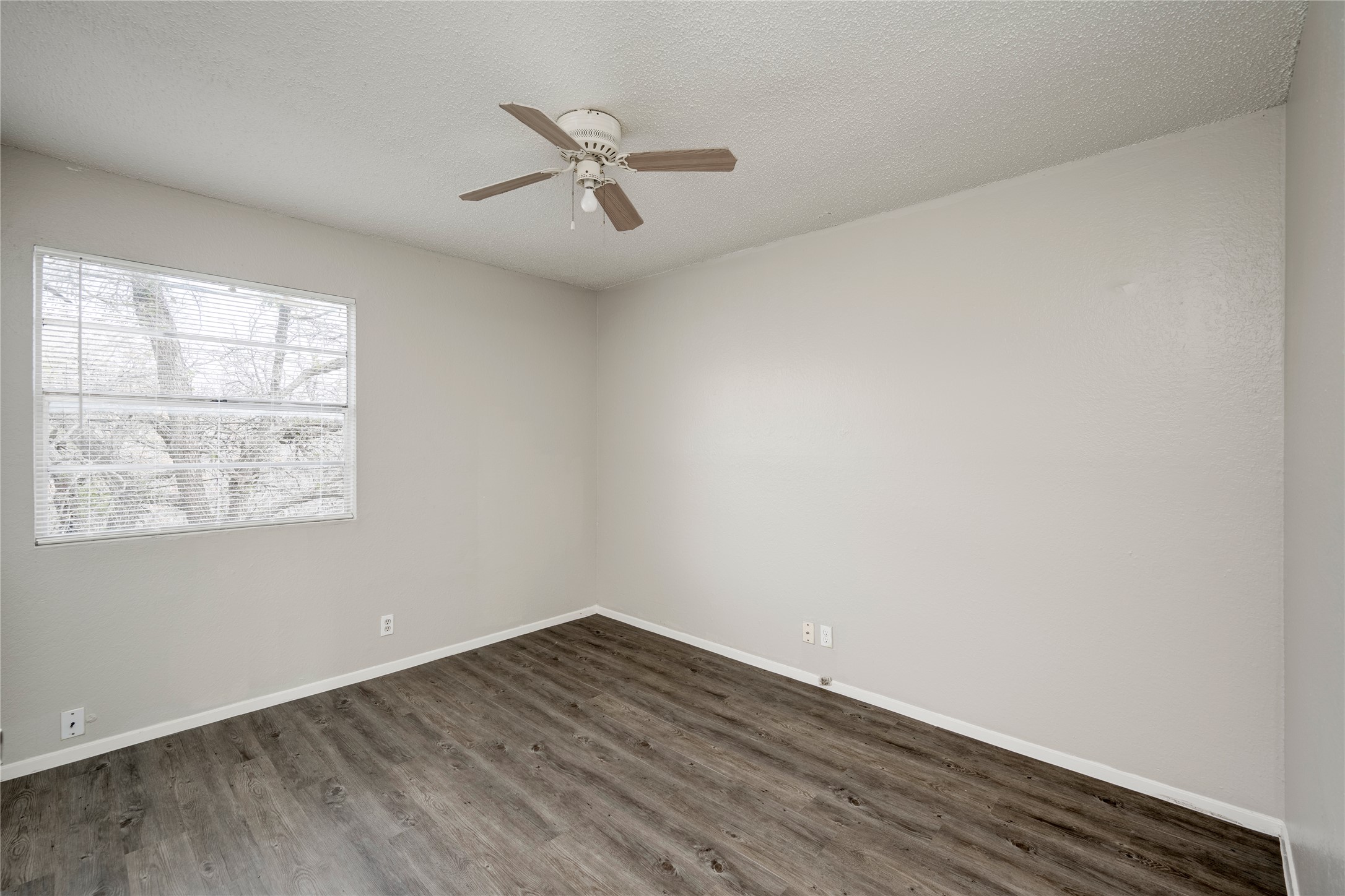 11907 Alpheus Avenue, Unit D Austin, TX 78759 - Photo 14 of 26 an empty room with wooden floor fan and windows