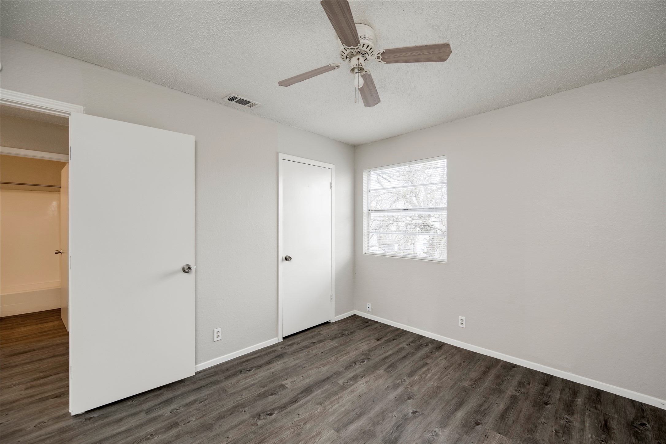 11907 Alpheus Avenue, Unit D Austin, TX 78759 - Photo 15 of 26 a view of an empty room with a window and wooden floor