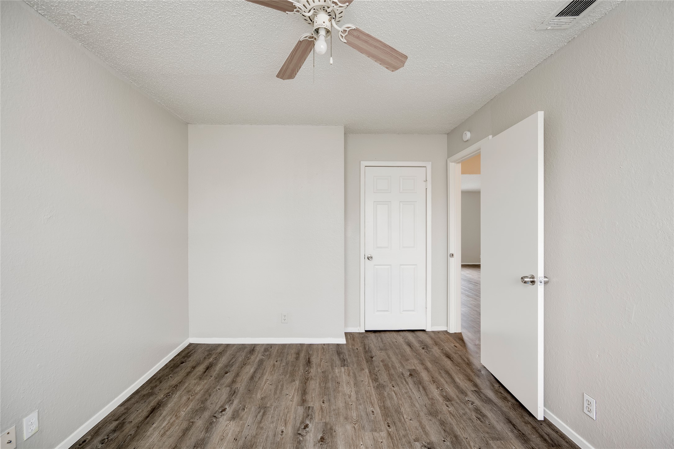 11907 Alpheus Avenue, Unit D Austin, TX 78759 - Photo 16 of 26 a view of an empty room with wooden floor and a ceiling fan