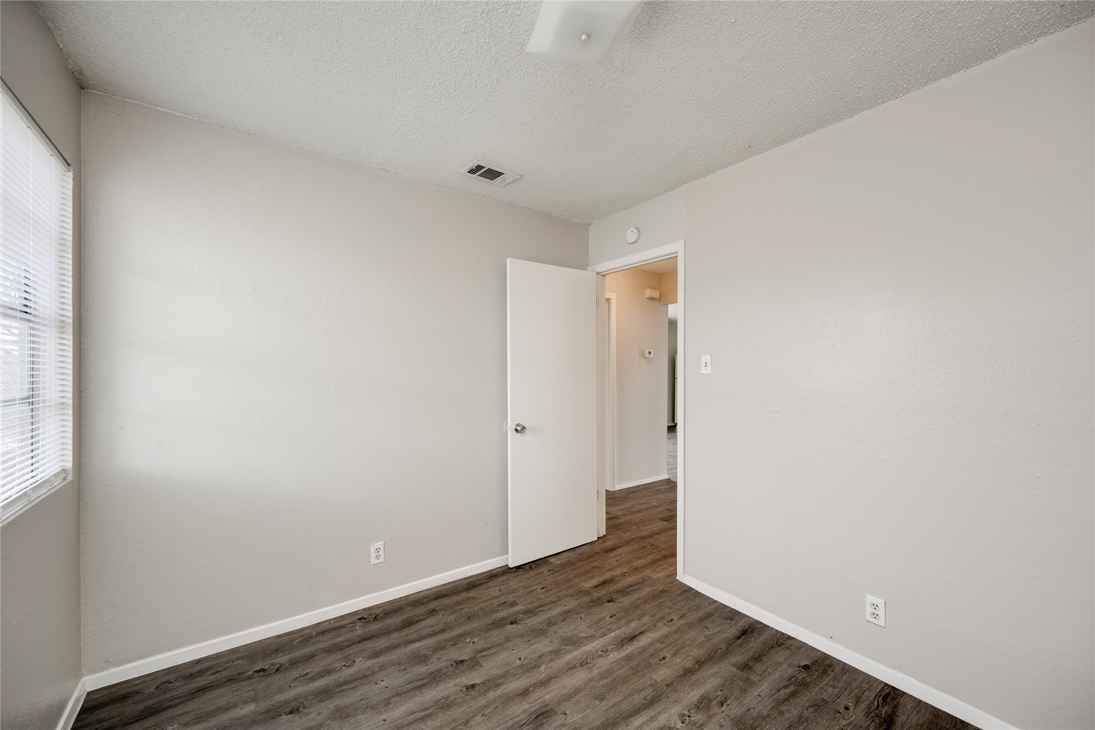 11907 Alpheus Avenue, Unit D Austin, TX 78759 - Photo 19 of 26 a view of an empty room with wooden floor and a window