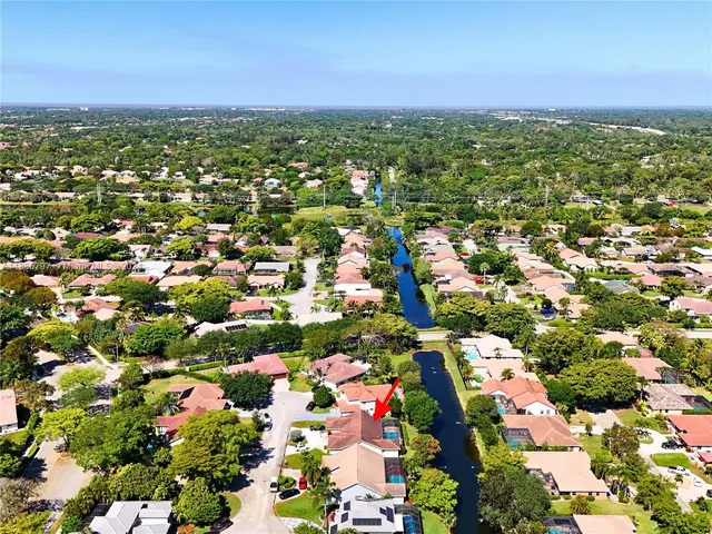 an aerial view of residential houses with outdoor space and trees