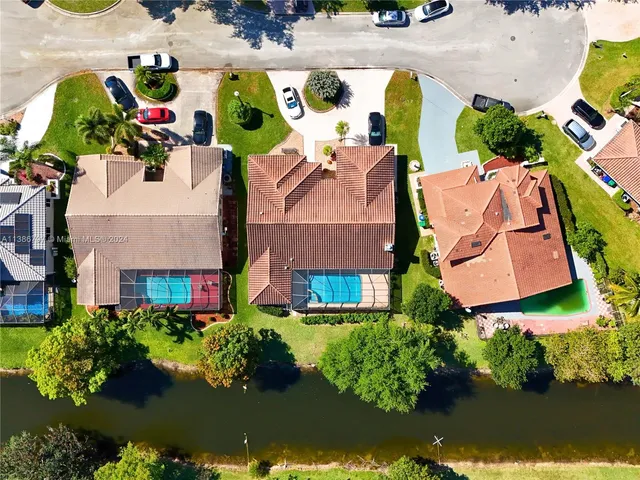 an aerial view of residential houses with outdoor space and swimming pool