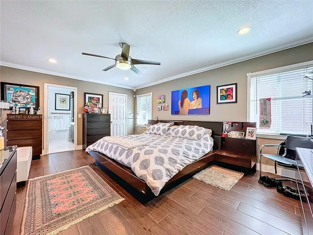 a bed sitting in a bedroom next to a window with a projector and a couch