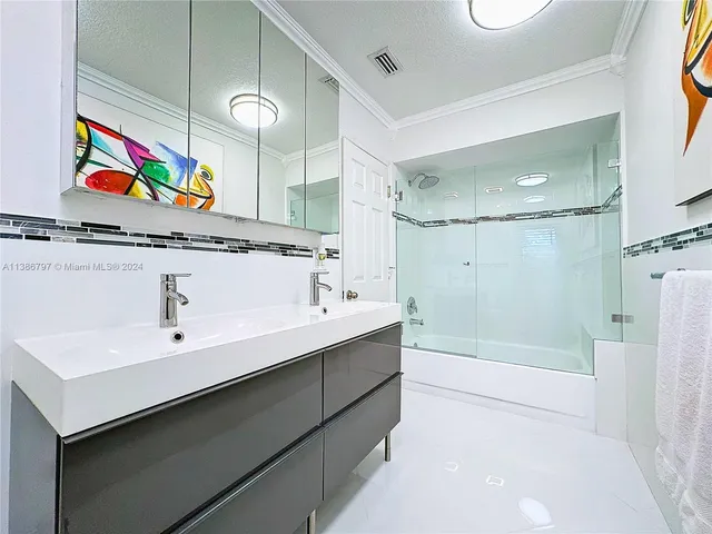 a bathroom with a sink a mirror a bathtub and shower