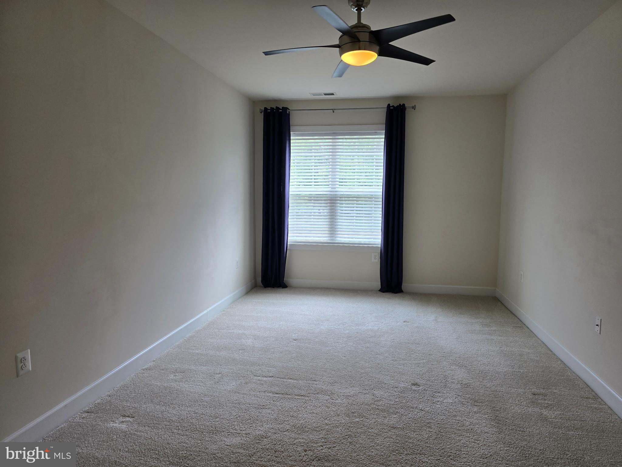 10530 Resort Road, Unit 101 Ellicott City, MD 21042 - Photo 9 of 13 an empty room with a window and ceiling fan