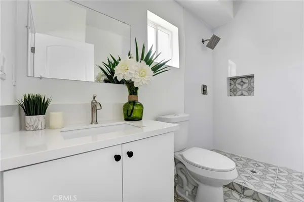 a bathroom with a sink a toilet and a mirror