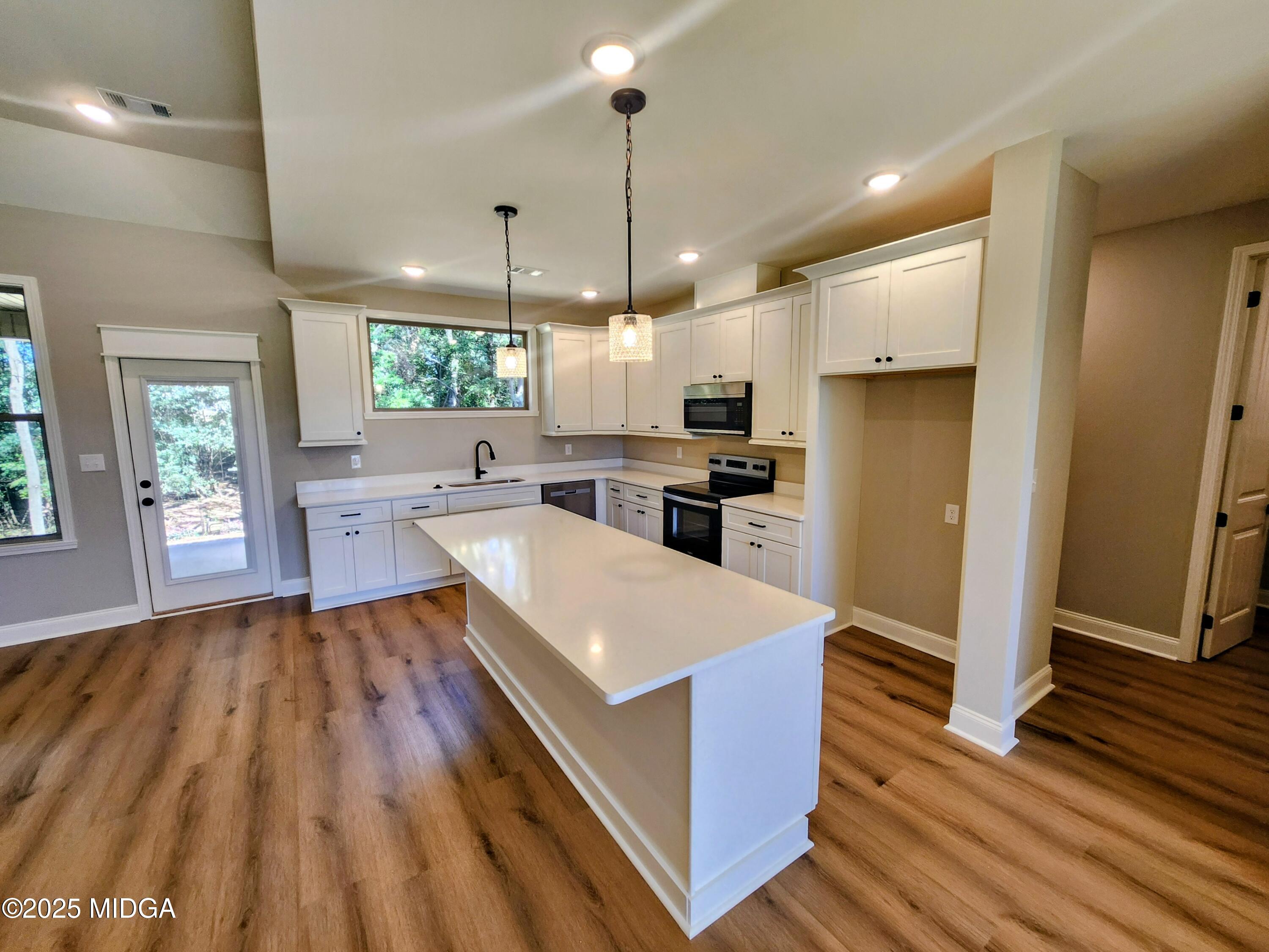 404 Minter Drive Warner Robins, GA 31088 - Photo 19 of 60 a large kitchen with stainless steel appliances granite countertop a refrigerator a sink dishwasher a stove and white countertops with wooden floor