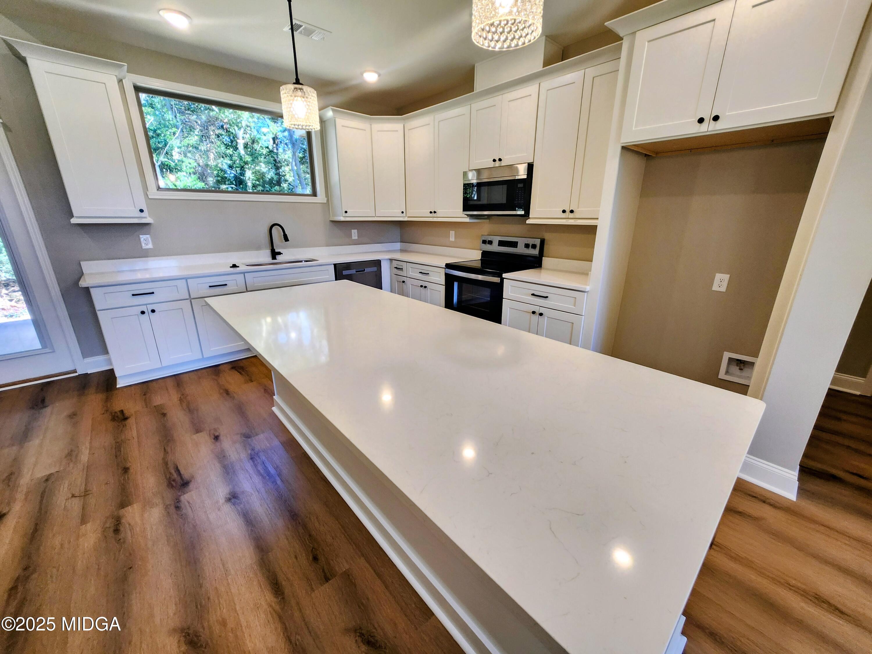 404 Minter Drive Warner Robins, GA 31088 - Photo 22 of 60 a large kitchen with wooden floors and stainless steel appliances