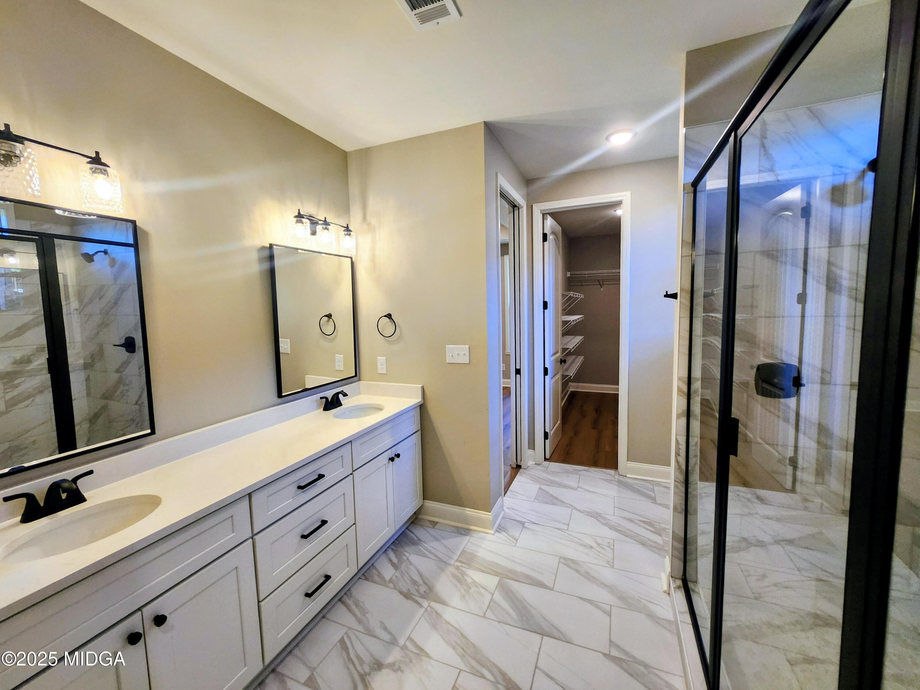 404 Minter Drive Warner Robins, GA 31088 - Photo 41 of 60 a spacious bathroom with a double vanity sink a large mirror and a shower