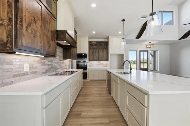 a large kitchen with stainless steel appliances lots of counter space sink and wooden floor