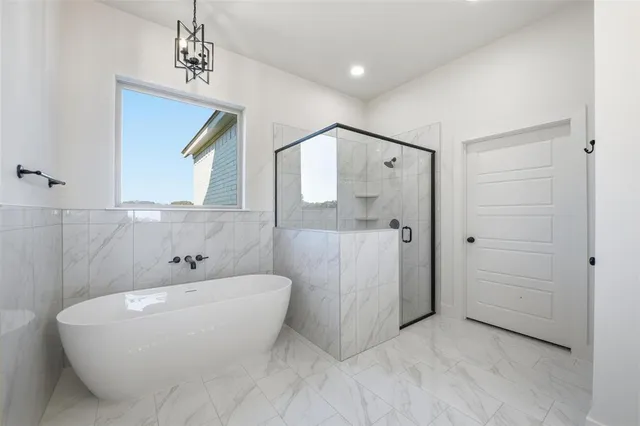 a bathroom with a white tub shower and mirror
