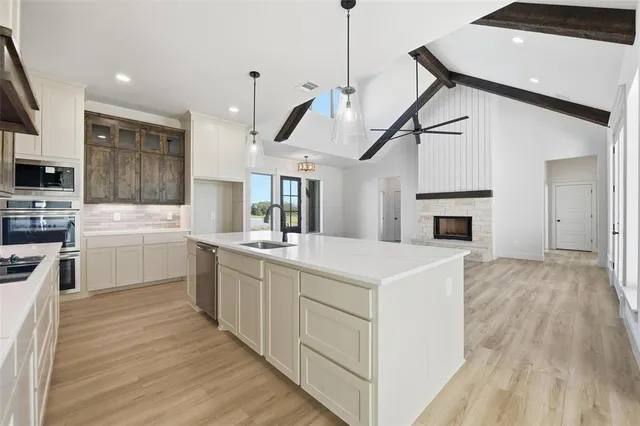 a kitchen with a sink a counter top space stainless steel appliances and a window