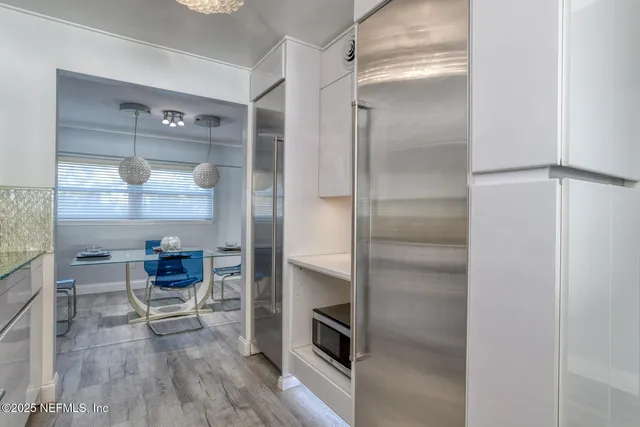 a kitchen with a refrigerator and wooden floor